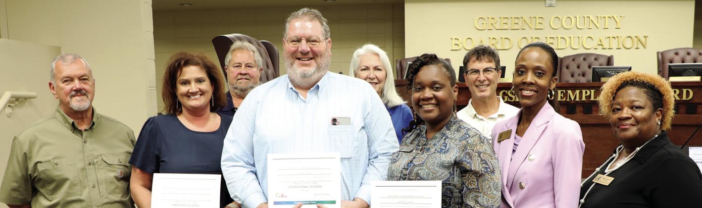 GCPS Principal Ashlie Miller, (left) GCHS Assistant Principal Dr. James Meneguzzo, (center left) and CMS Principal Tanisha Wright (center right) receive their schools’ PBIS recognitions from the state at Thursday night’s BOE meeting from Assistant Superintendent Dr. Rotonya Rhodes (right) along with the BOE members. (CONTRIBUTED)