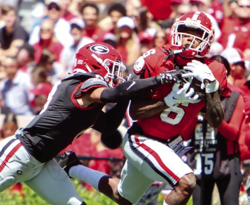 Georgia wide receiver Dominic Lovett (6) makes an over-the-shoulder catch over a defender. LANCE McCURLEY/Staff